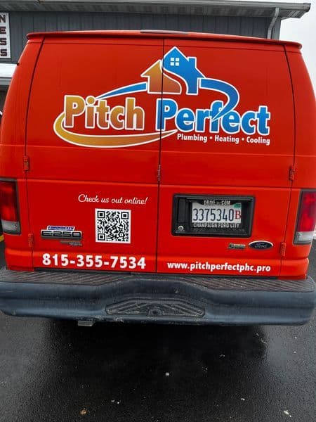 Back of a Pitch Perfect plumbing van featuring contact information and QR code for services.