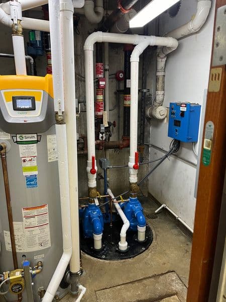 Water heating equipment and plumbing system with valves in a mechanical room.