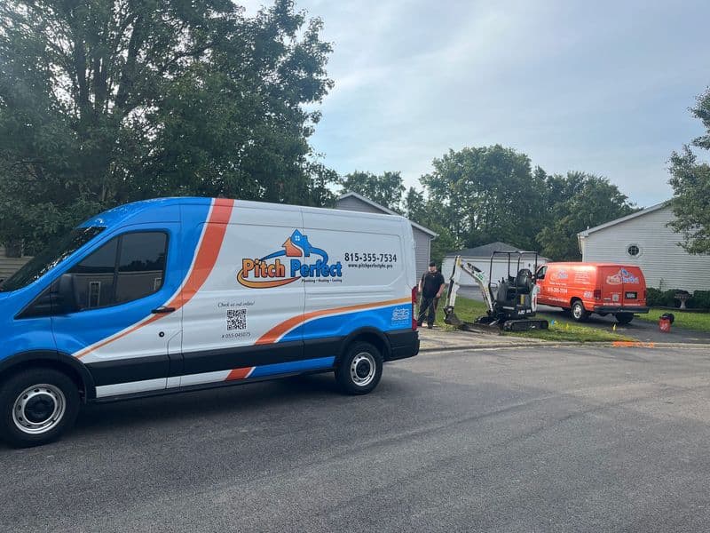 Pitch Perfect service vans parked at a residential site, with workers on job.