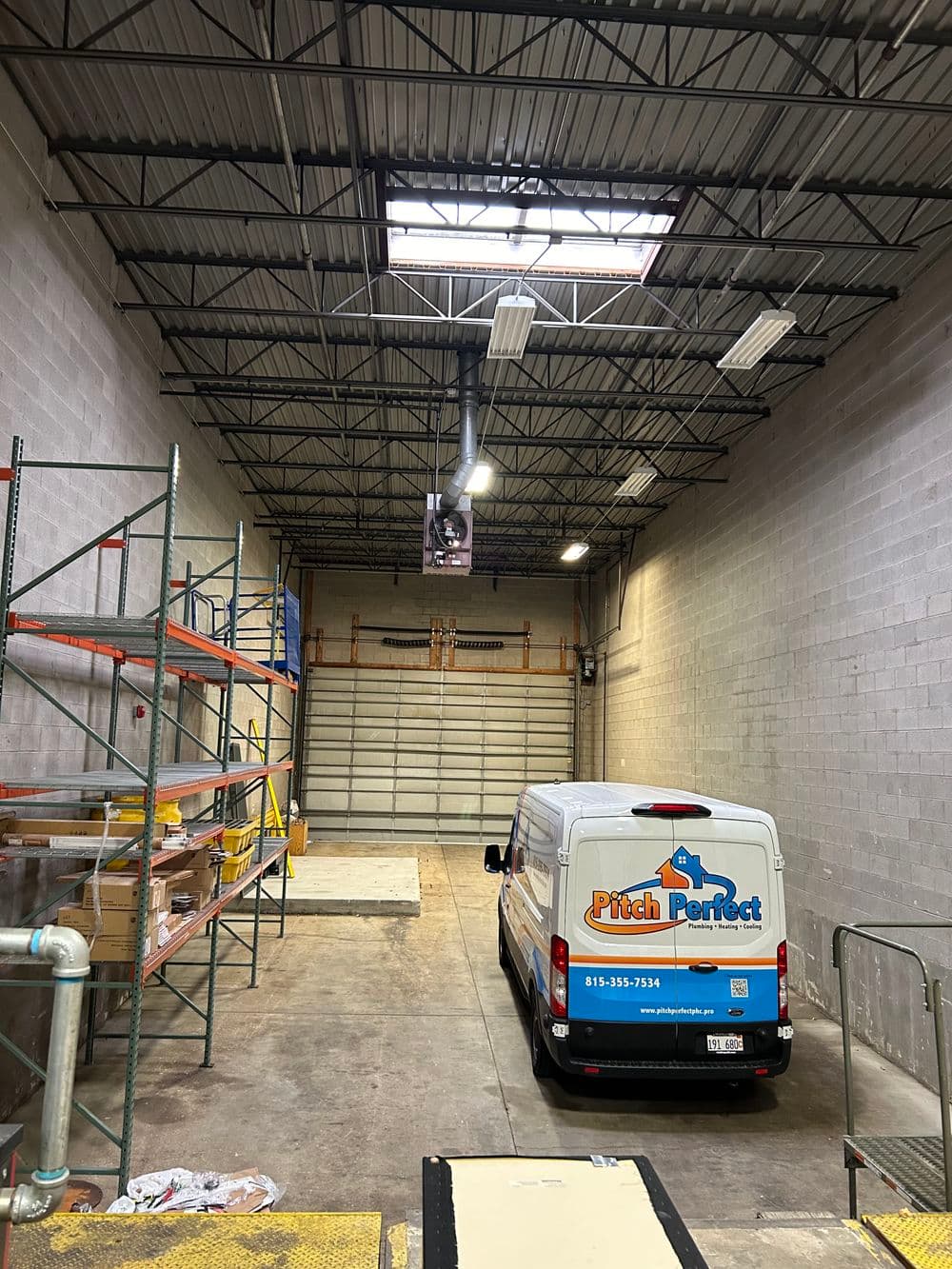 Pitch Perfect van inside a spacious industrial warehouse with shelving and loading dock.